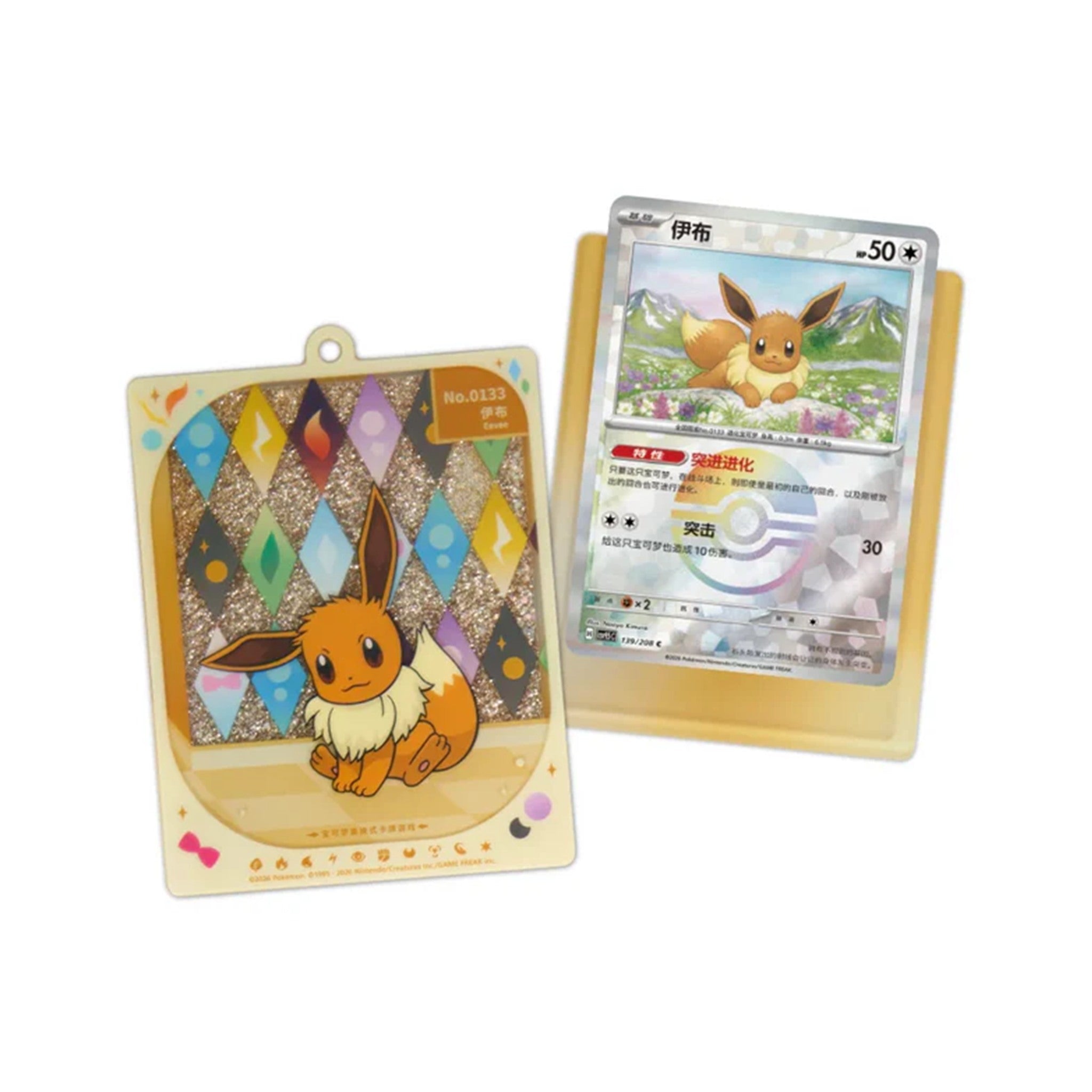 Pendentif porte-carte Évoli à sable pailleté avec son mousqueton, à côté de la carte Évoli assortie dans son support